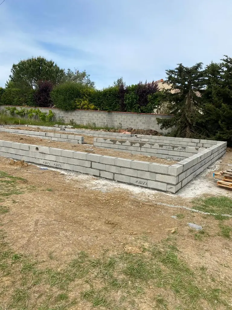 Fondations en parpaings prêtes pour l'élévation d'une structure, exemple de gros œuvre