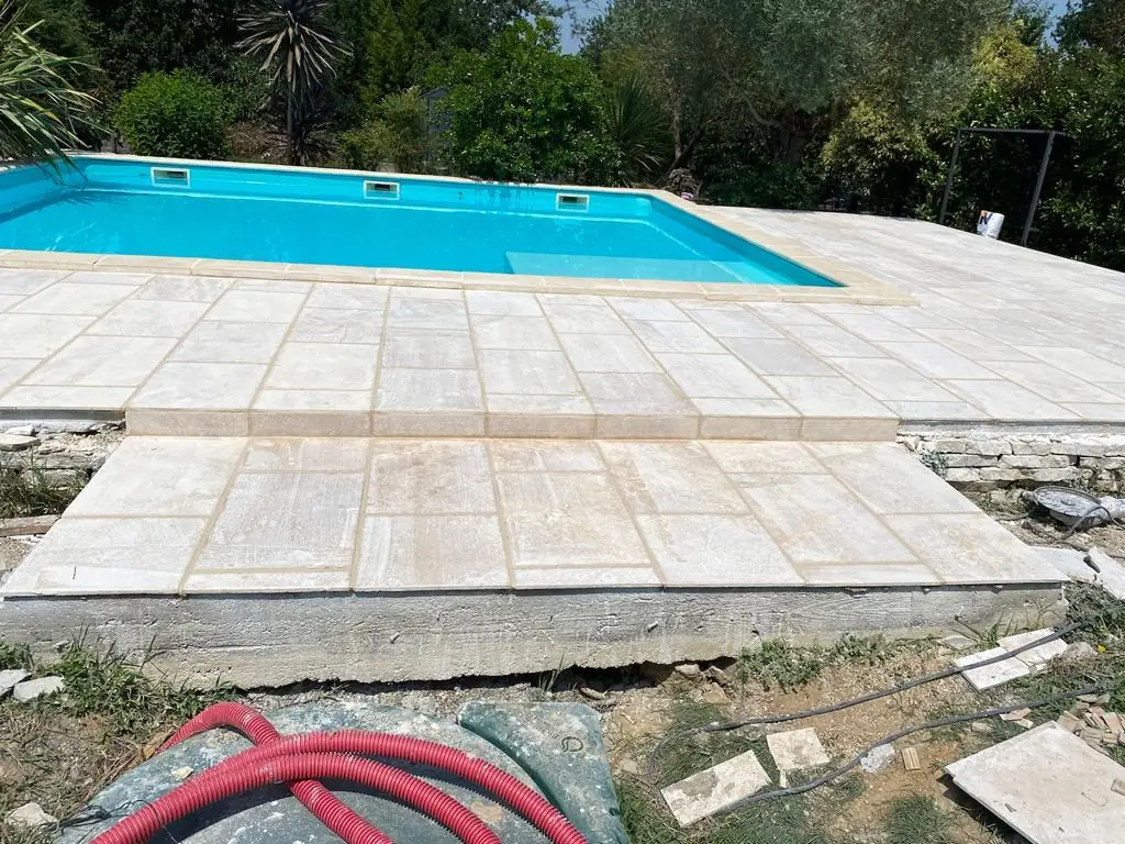 Plage de piscine dallée en pierre naturelle, vue d'ensemble