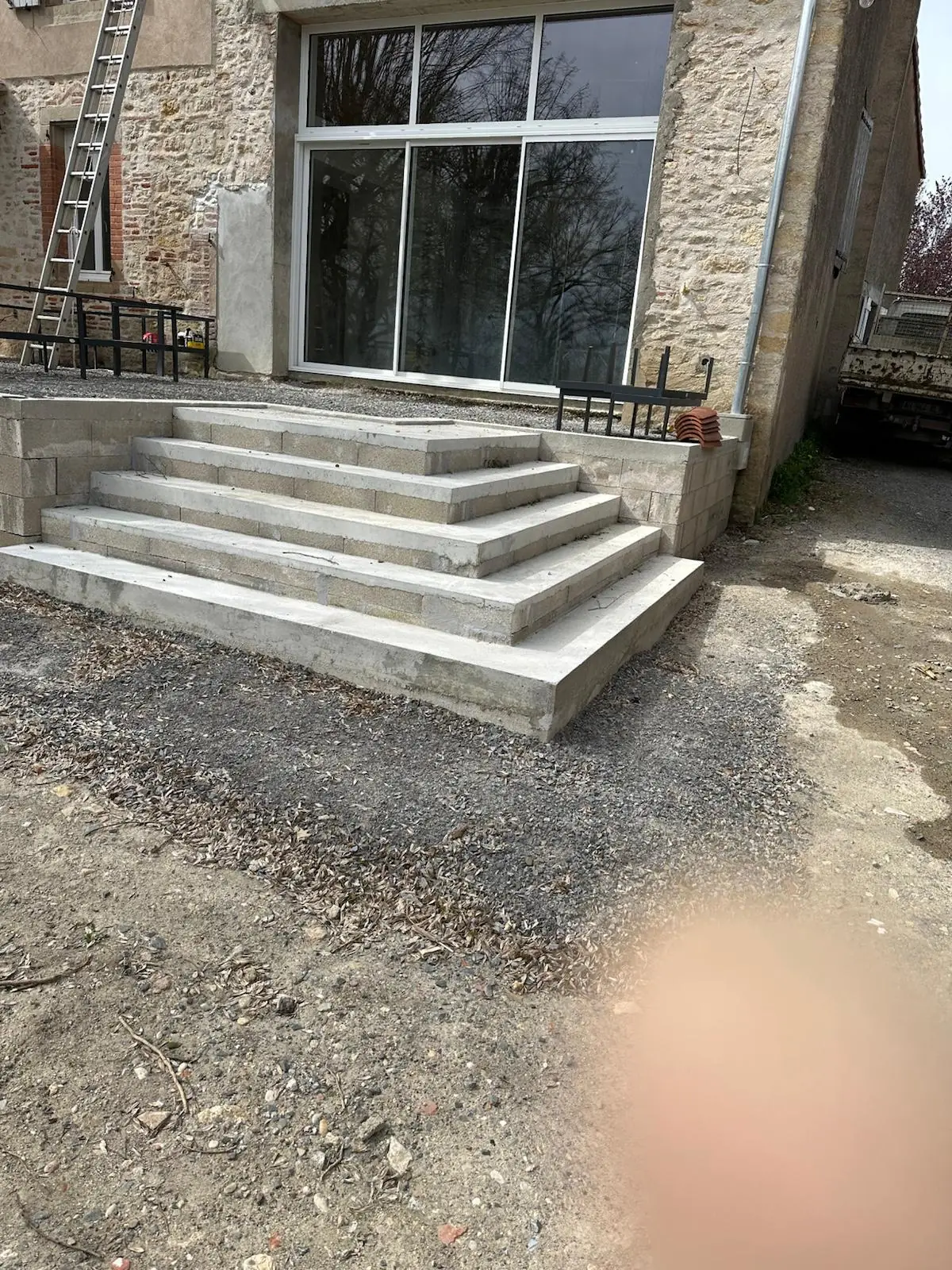 Escalier extérieur en pierre reconstituée devant une maison ancienne
