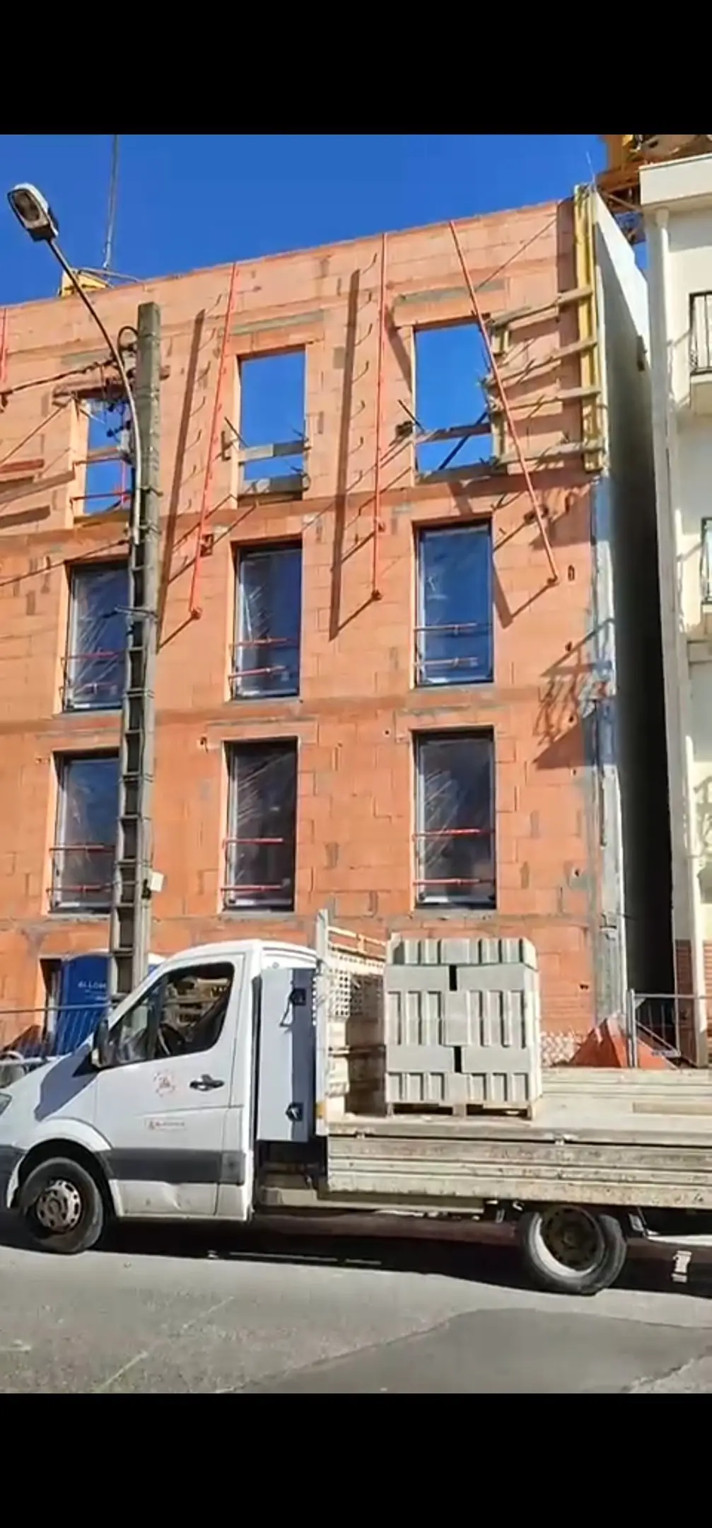 Immeuble en construction en brique avec échafaudage, chantier urbain