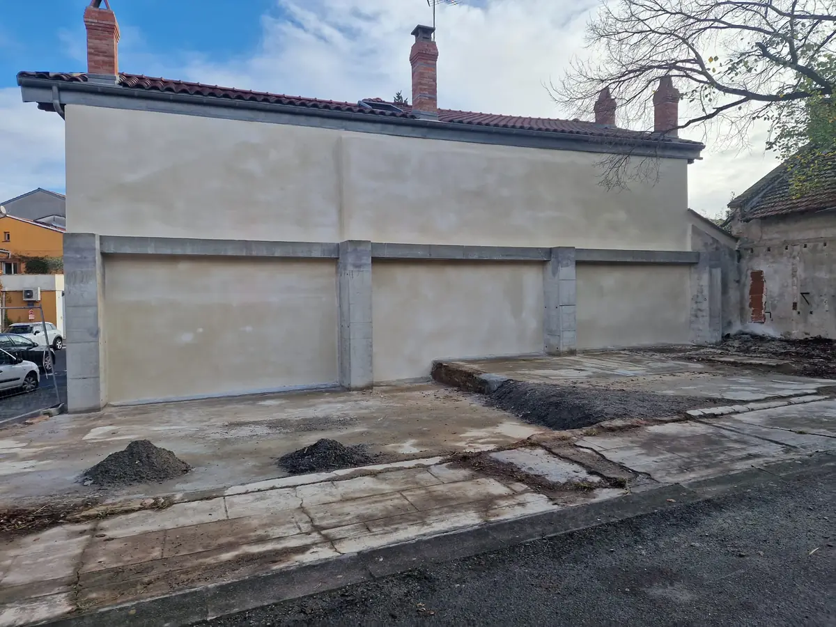 Façade fraîchement enduite d'un bâtiment annexe avec toiture en tuiles